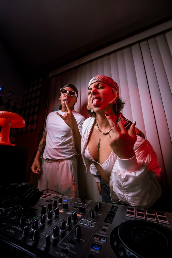 Energetic DJ party scene with young adults in a vibrant indoor setting, expressing fun and rebellion.